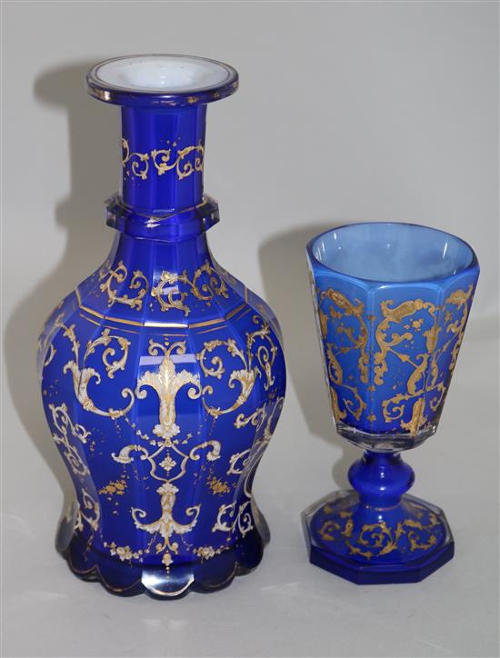 A Bohemian gilt decorated and white enamelled blue glass decanter and matching goblet, late 19th century, 26.5cm and 17.3cm, manufactur